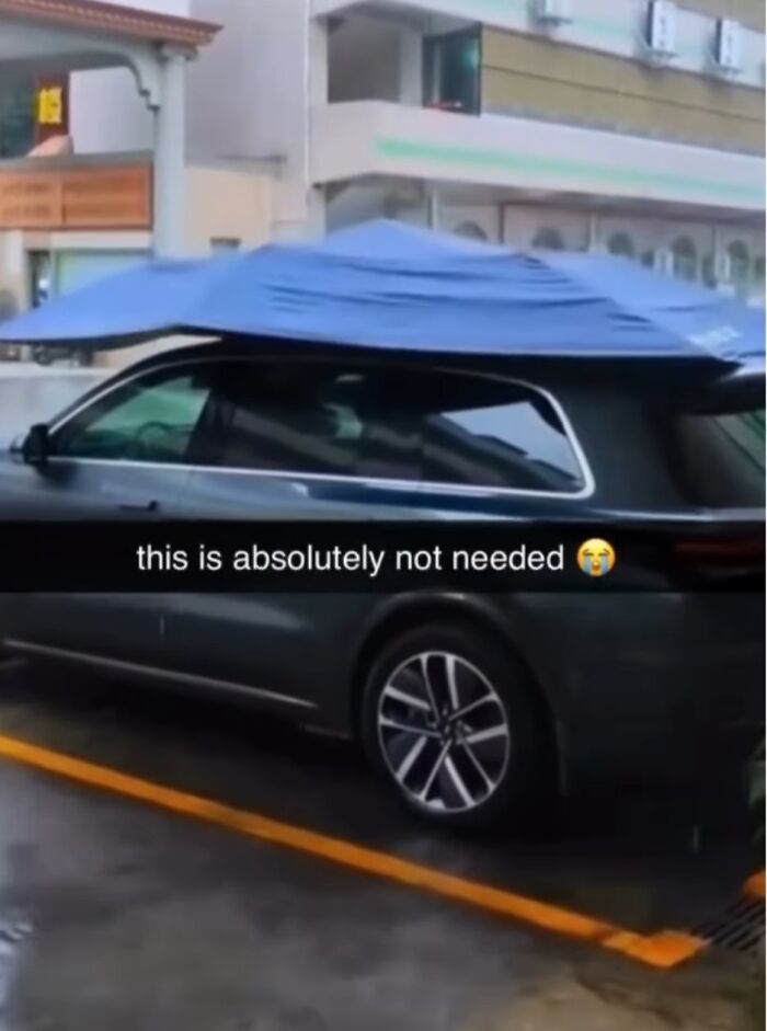 Car with an umbrella-like cover parked on the street, illustrating a hilarious meme about unnecessary inventions.