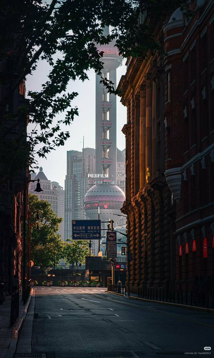 A street scene with old and modern buildings, including a unique tower, reminiscent of an evil mastermind's city.