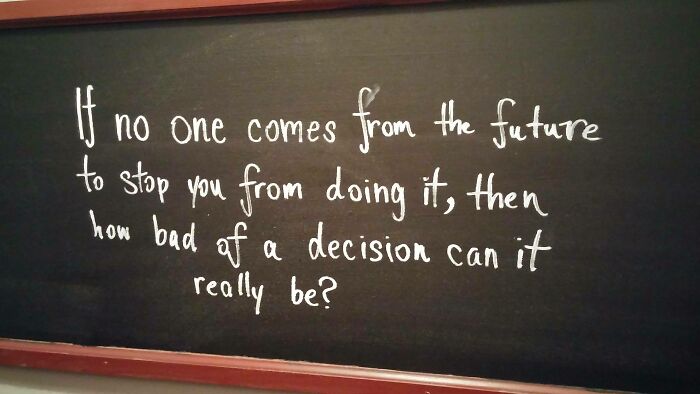 Chalkboard with a funny piece of advice written in white about decisions and the future for funny advice content.