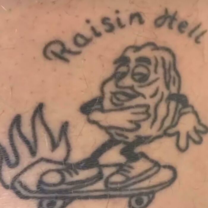 Black ink tattoo of a cartoon raisin character skateboarding with flames, a funny and awful permanent tattoo example.