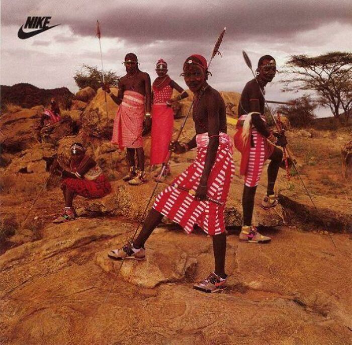 African tribesmen dressed in traditional attire wearing Nike sneakers, blending cultural heritage and modern footwear.