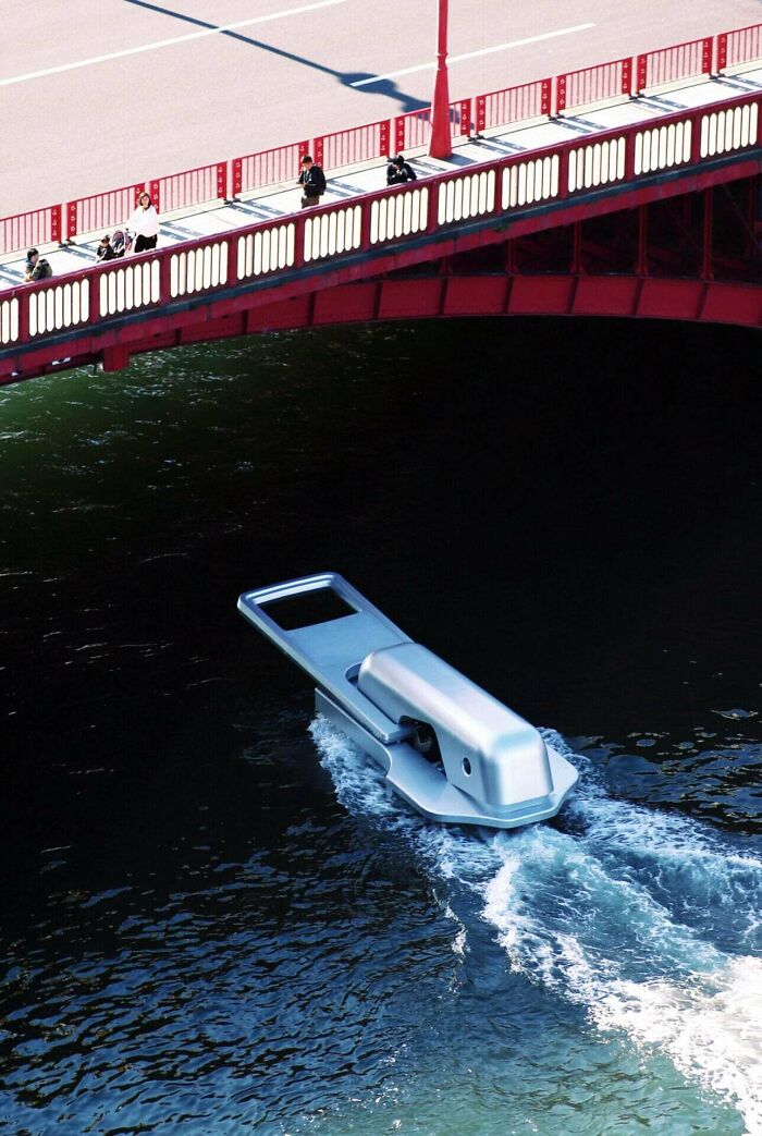 Boat shaped like a giant nail clipper cruising under a red pedestrian bridge – interesting vault of bizarre oddities.