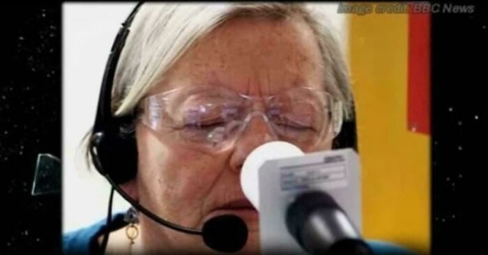 Elderly woman with headset and protective glasses closely examining equipment in an interesting vault story setting.