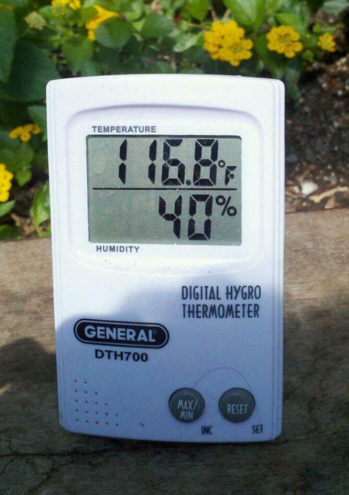 Digital thermometer displaying extreme temperature of 116.8°F and 40% humidity, highlighting workplace heat conditions.