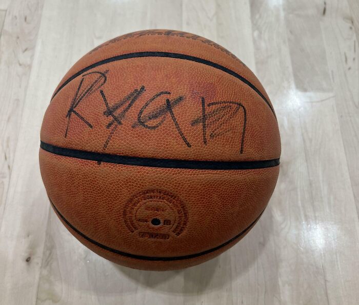 Autographed basketball on a gym floor, showcasing a signature that surprises people at the gym.