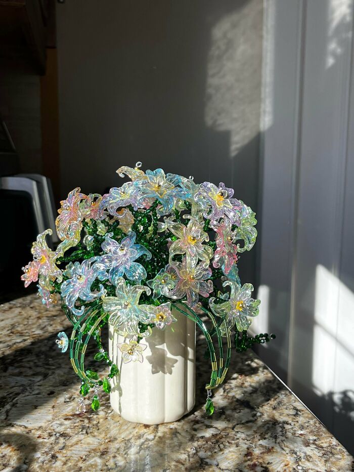 A vase filled with delicate, colorful beaded flowers, a beautiful handmade project.