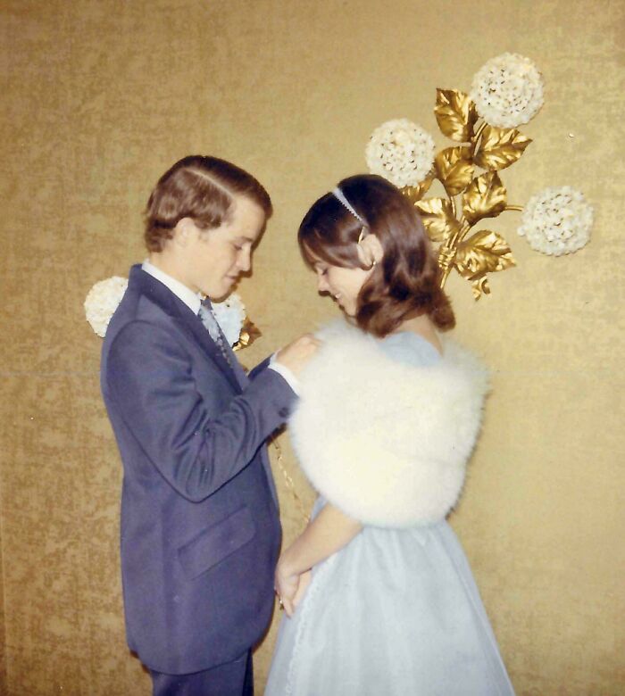 A candid old photo shows a couple dressed formally against a patterned wall, revealing what the world looked like generations ago.