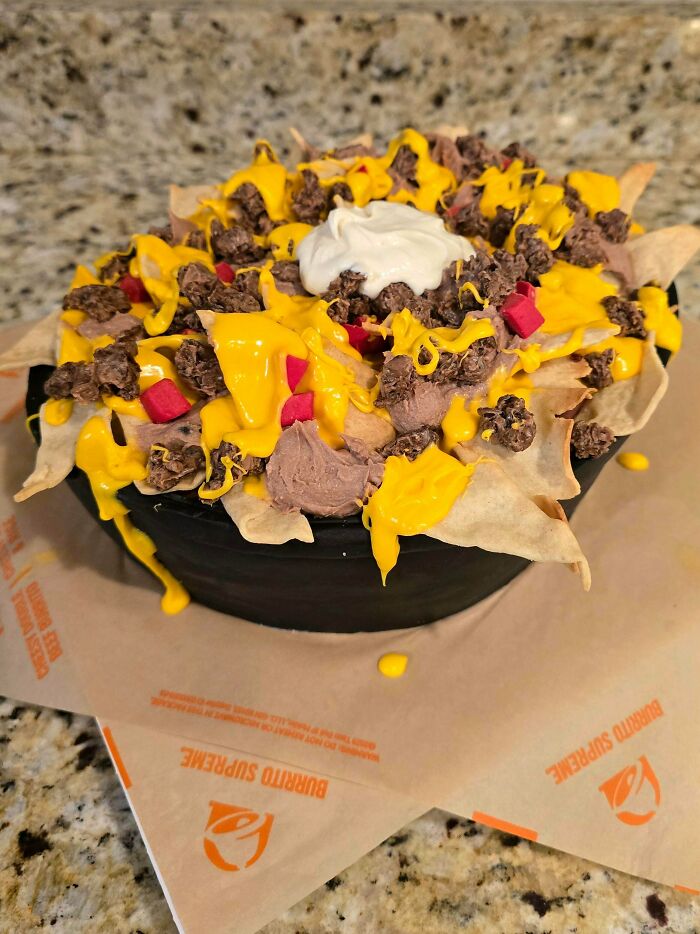 Creative nacho-style cake topped with chocolate, cheese, and sour cream