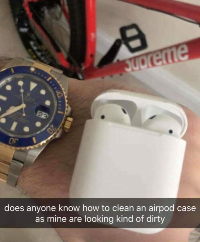 Close-up of hand wearing a watch holding AirPods case with dirty appearance, illustrating cringe-worthy moments.