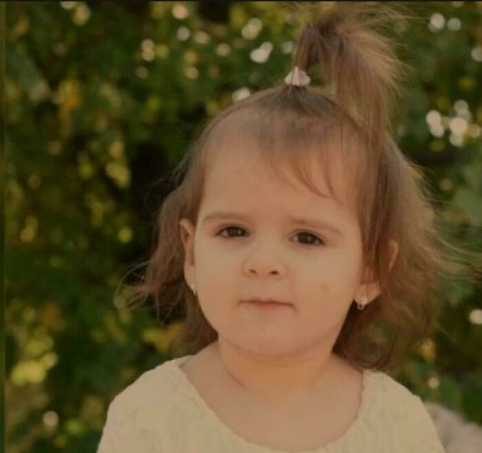 Young girl with a serious expression outdoors, evoking unsettling mysteries that continue to fascinate and disturb viewers.