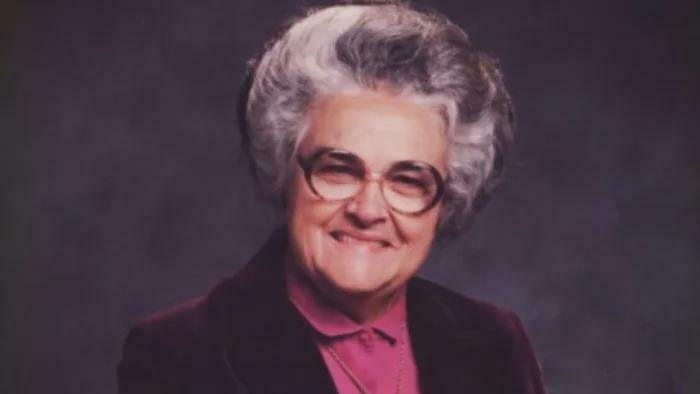 Elderly woman with gray hair and glasses smiling softly in portrait, related to unsettling mysteries topic.