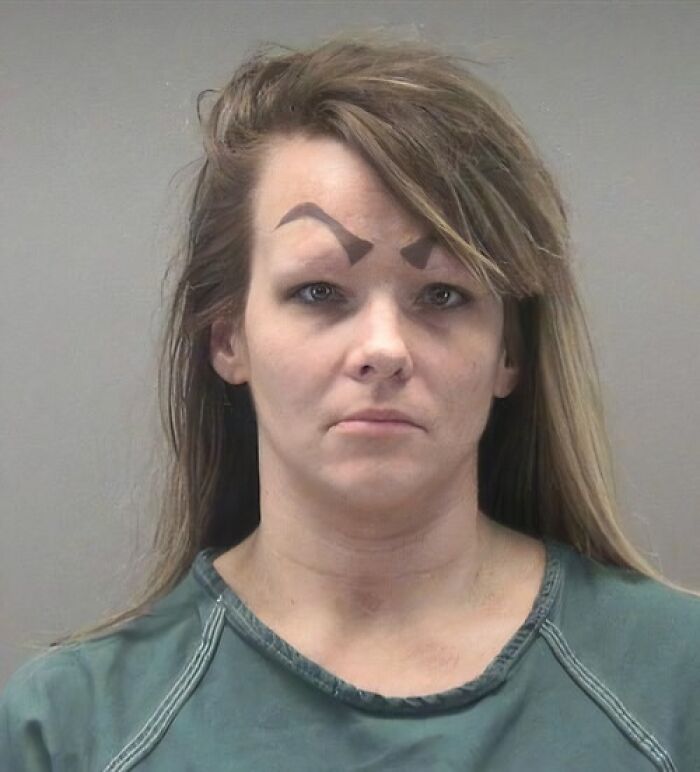 Woman with crazy eyebrows drawn in unusual shapes, giving the appearance of eyebrows living their own lives on her face.
