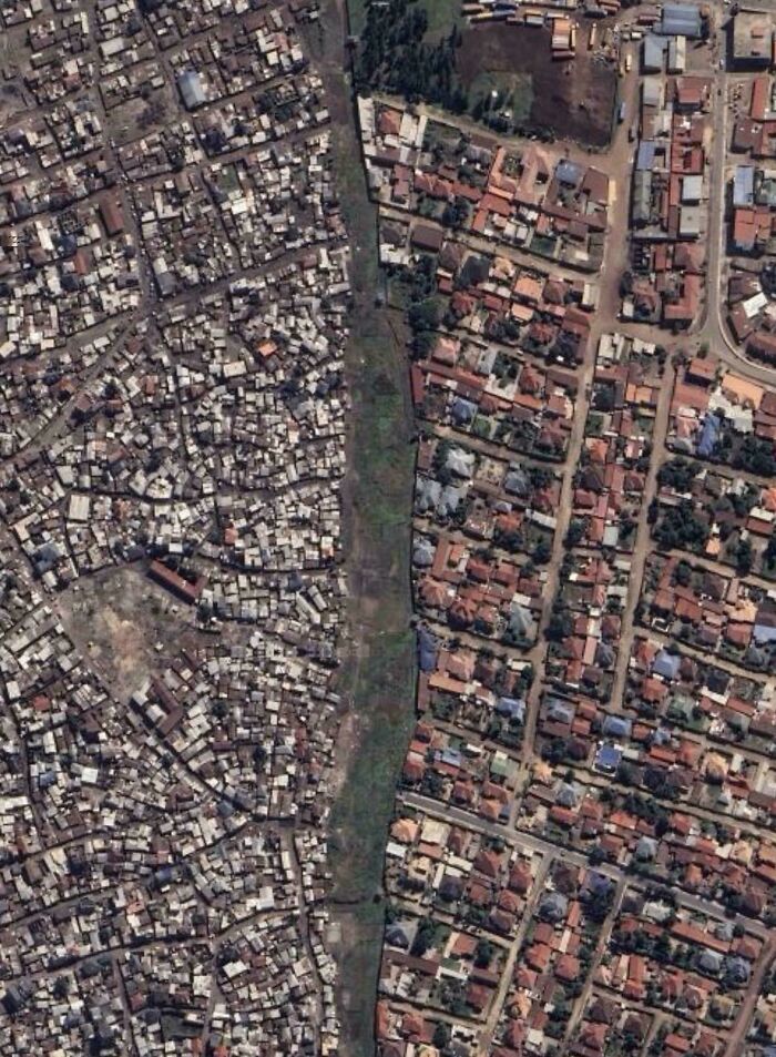 Aerial contrast between dense slum and orderly urban residential neighborhood
