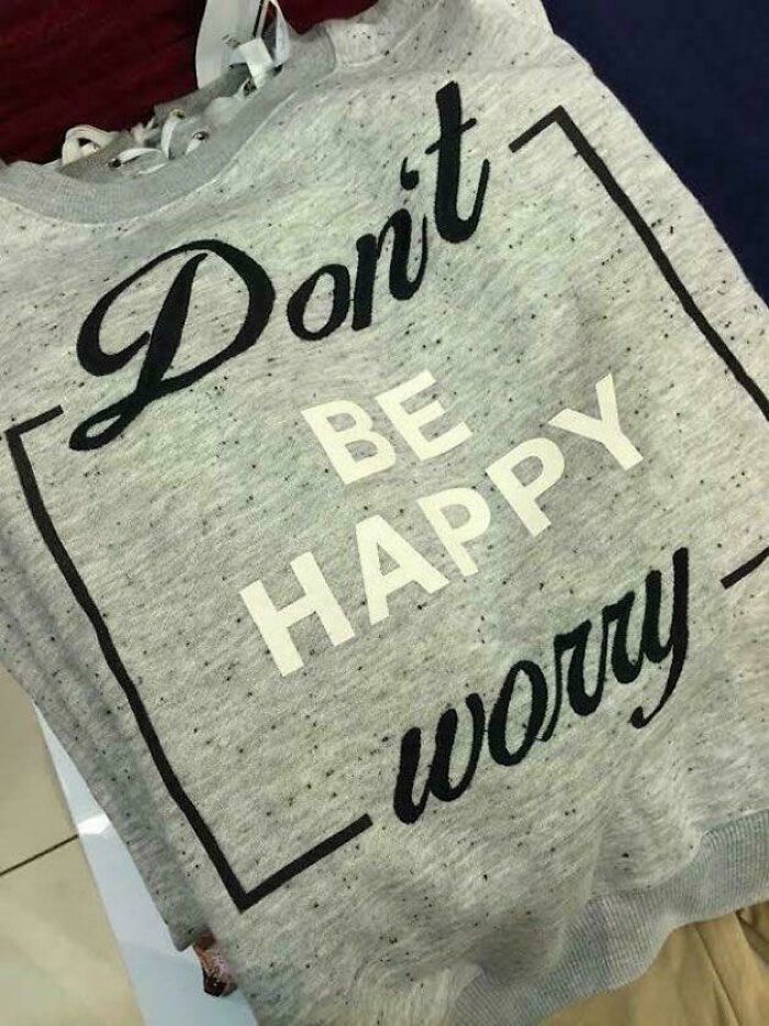 Grey t-shirt with a badly designed message that reads don't be happy worry, showcasing funny bad t-shirt designs.