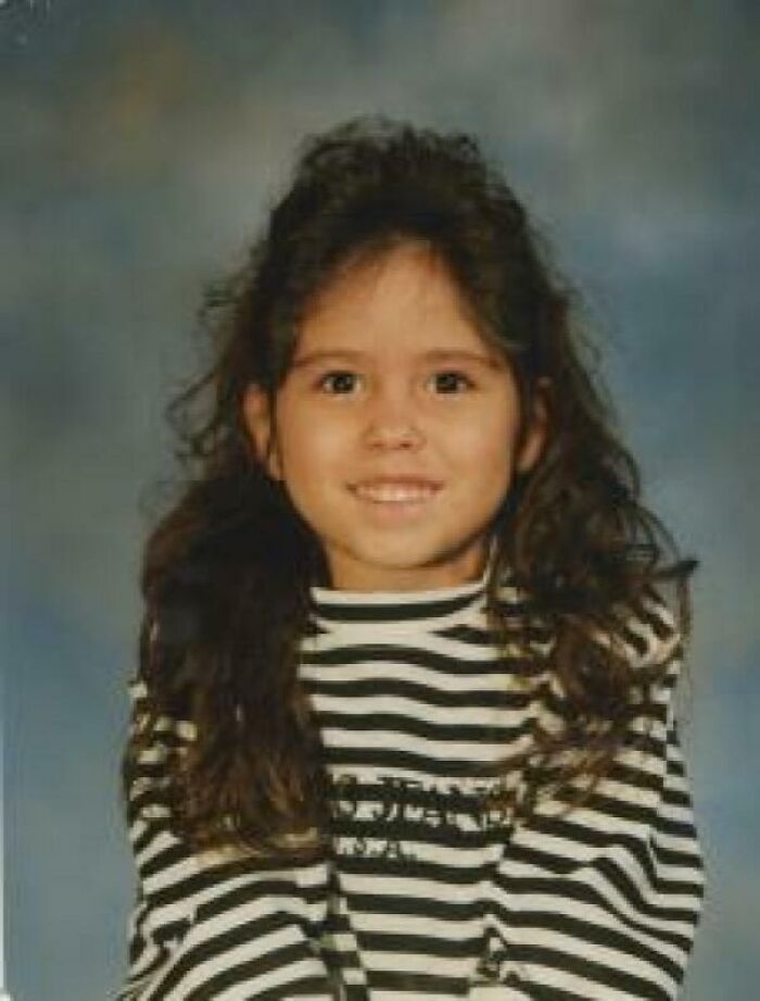 Portrait of a young girl with long curly hair wearing a striped shirt, linked to unsettling mysteries that fascinate and disturb.