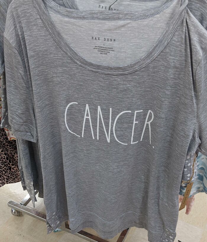 Gray t-shirt with the word cancer printed in large white letters, showcasing one of the hilariously bad t-shirt designs.