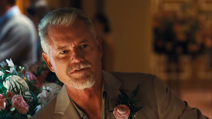 Older man with gray hair and beard wearing a suit with a floral boutonniere in a scene from Euphoria Season 3.