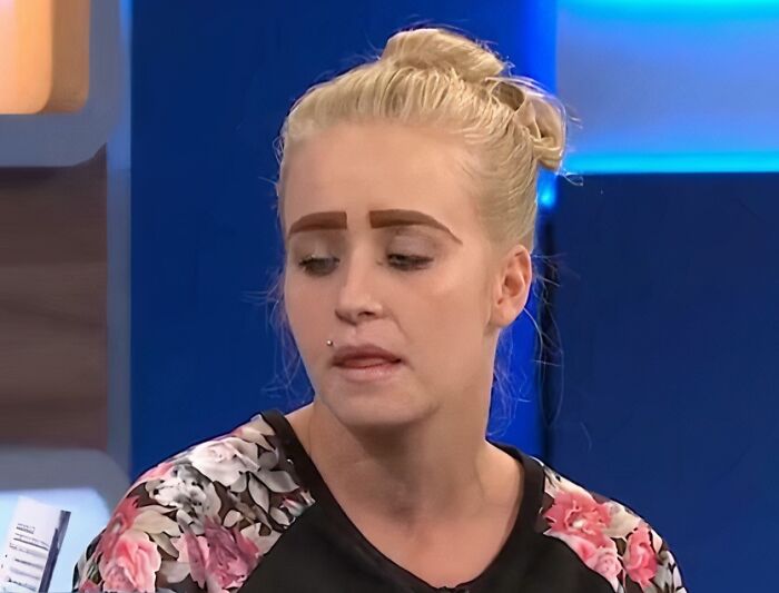 Woman with crazy eyebrows styled in a bold, block shape, appearing to live their own lives on her face.