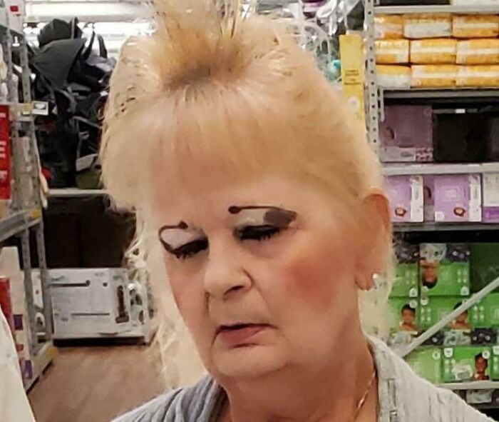 Woman inside a store with crazy eyebrows styled oddly, giving the impression they live their own lives on her face.