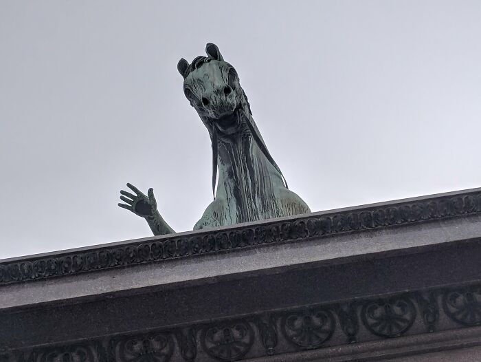 Creepy and weird photo of a horse statue with a raised hand-like hoof, creating eerie heebie-jeebies effect.