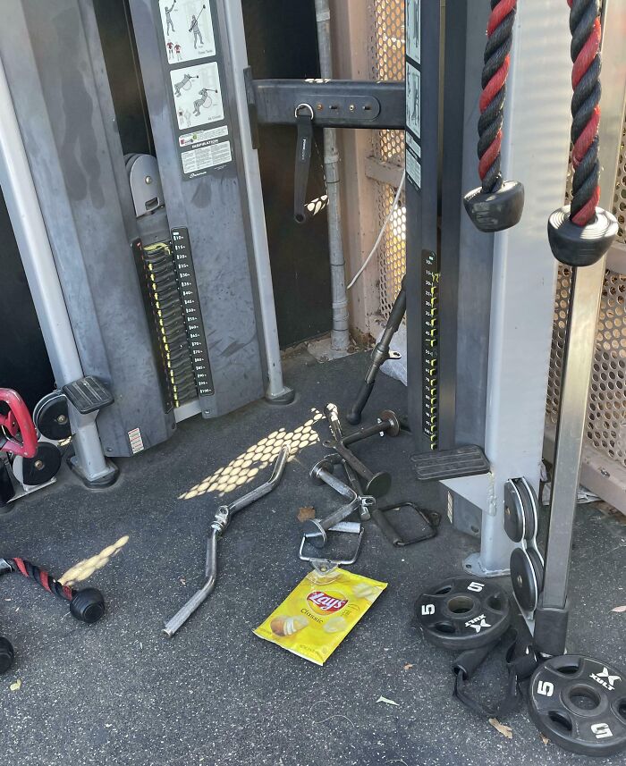 Gym equipment cluttered on floor with weights and a chip bag, showcasing a Darwin Award contender moment.