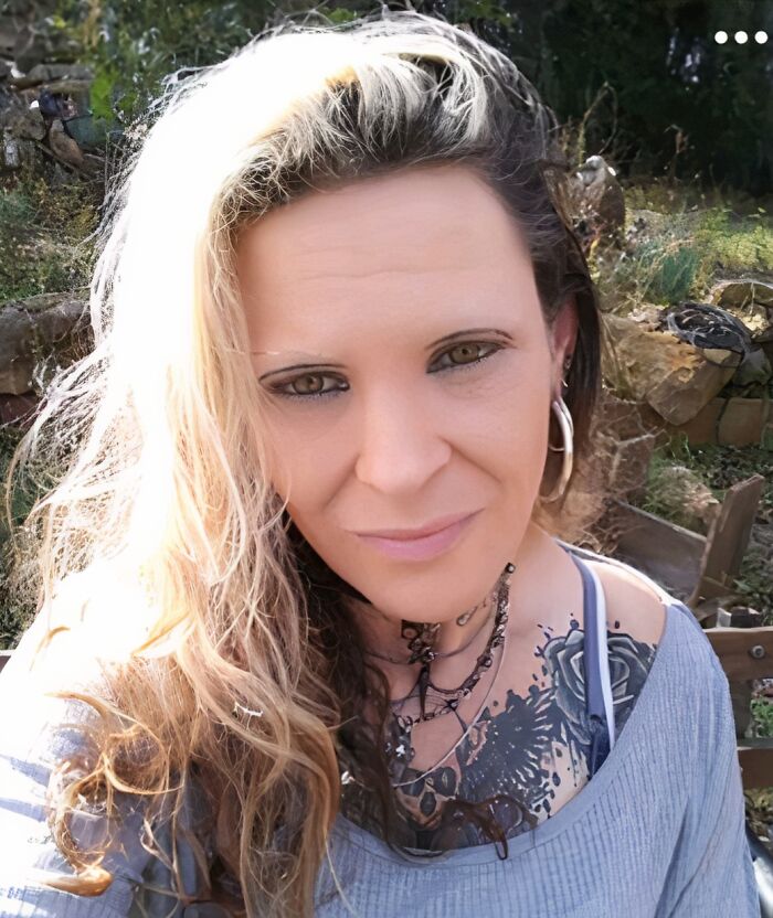 Woman outdoors with blonde hair and thin, uniquely shaped crazy eyebrows seemingly living their own lives on her face.