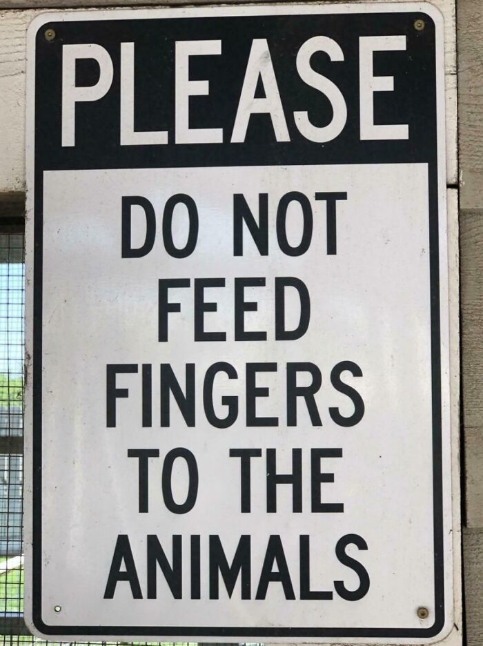 Funny pieces of advice sign warning visitors not to feed fingers to the animals in a humorous way outdoors