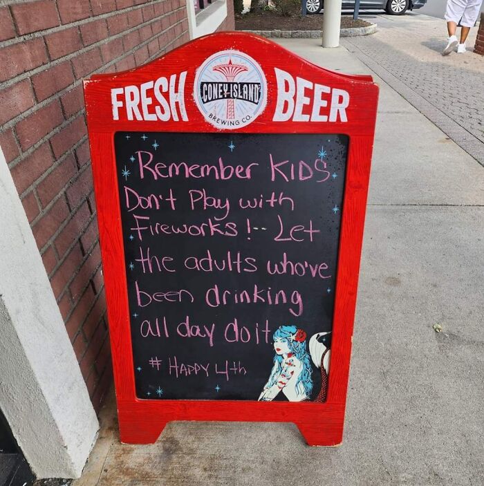 Chalkboard with funny pieces of advice about fireworks and drinking outside a brewery on sidewalk