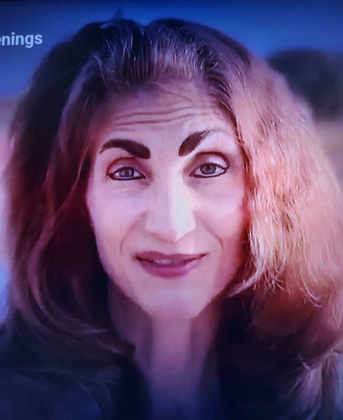 Woman with crazy eyebrows styled unusually, creating a striking and expressive look on her face.