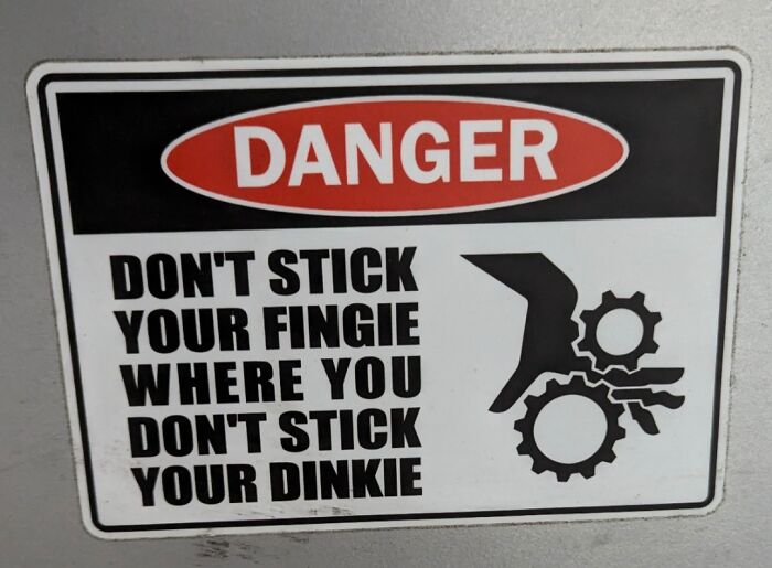 Funny pieces of advice warning sign showing a safety message about not sticking fingers into machinery gears.