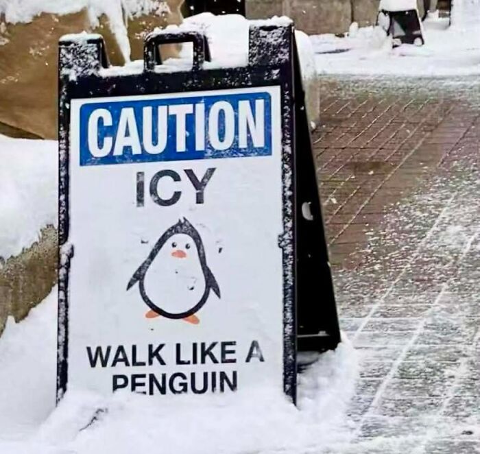 Caution icy sidewalk sign with cartoon penguin giving funny pieces of advice to walk like a penguin to prevent slipping.