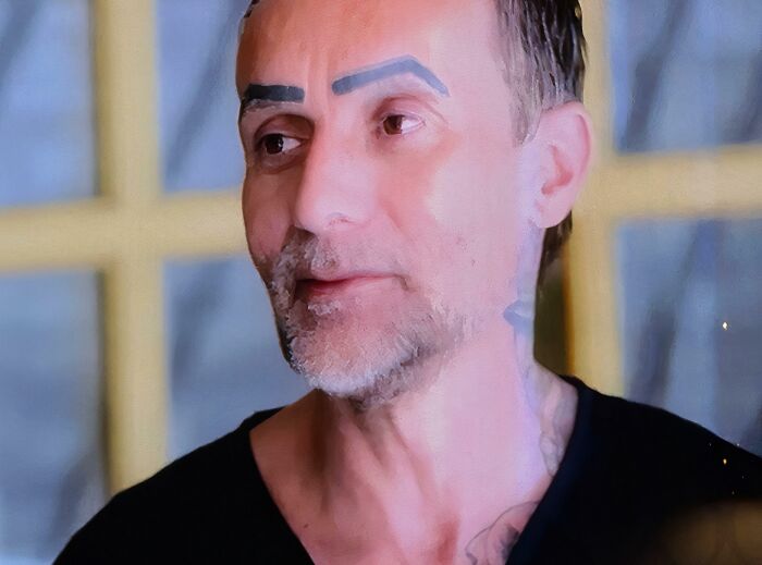 Middle-aged man with thick, crazy eyebrows styled oddly, creating a unique and striking facial expression.