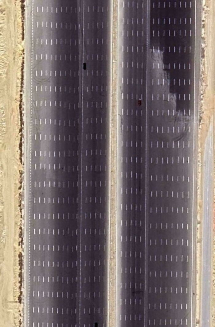 Aerial view of an empty large urban parking lot under bright light