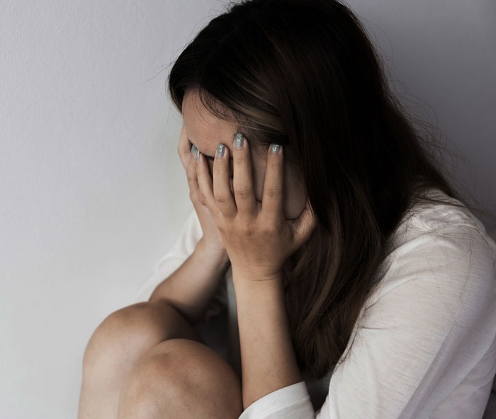 Woman sitting alone with her face in hands, showing a horrible feeling about brother-in-law and protecting her daughter. Woman sitting alone with her face in hands, showing a horrible feeling about brother-in-law and protecting her daughter.