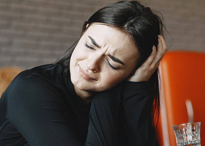Woman showing distress and worry while hiding a one night stand secret from her boyfriend in a tense moment.