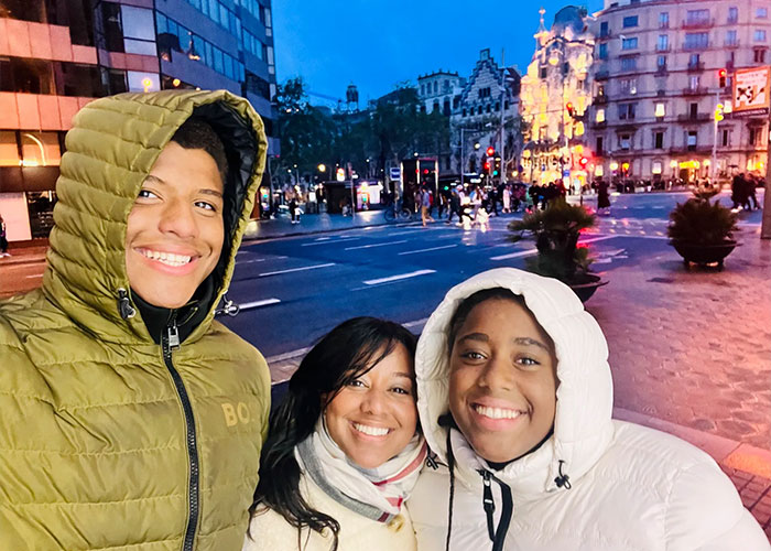 Three people smiling outdoors at dusk in a city setting, related to star water polo player incident claims. Three people smiling outdoors at dusk in a city setting, related to star water polo player incident claims.