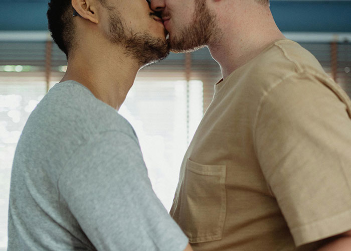 Two men sharing an intimate moment, symbolizing a messy love triangle and chaotic romantic secrets revealed.