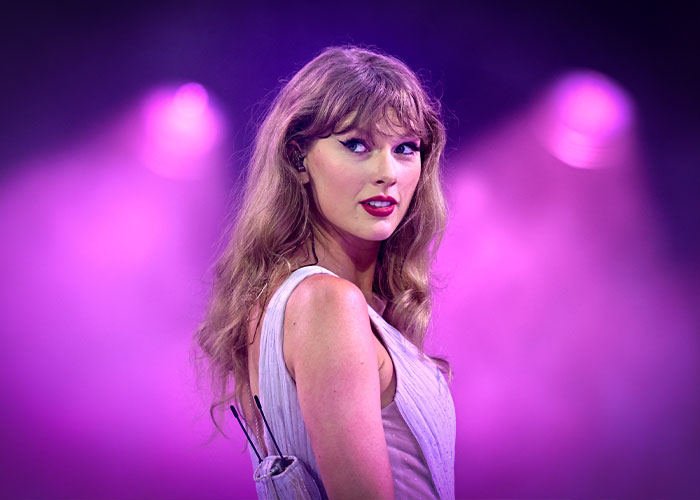 Taylor Swift on stage under purple lights, highlighting the backlash and Jack White&rsquo;s response in the music industry.