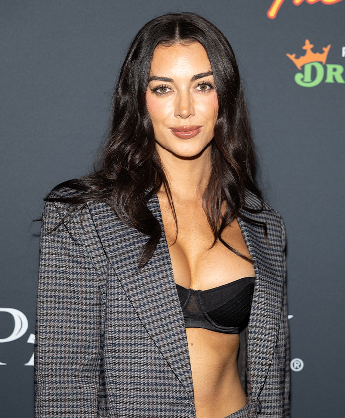 Brianna Chickenfry posing at an event, wearing a checkered blazer and black crop top, warning about weight loss injections.