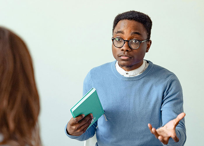 Man in glasses and blue sweater holding a notebook, sharing the moment his ex revealed who they really were.