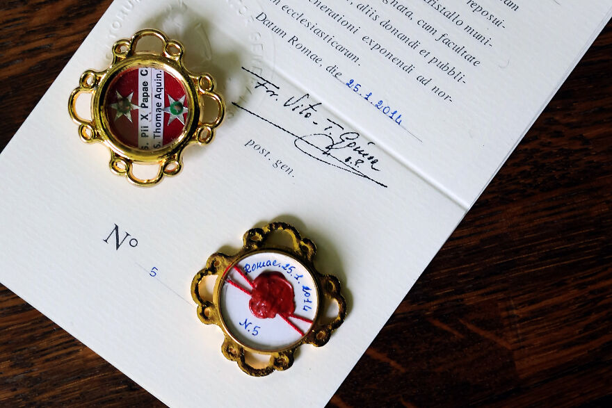 Two curious objects with gold frames and seals placed on a signed document, showcasing origins more dazzling than expected.