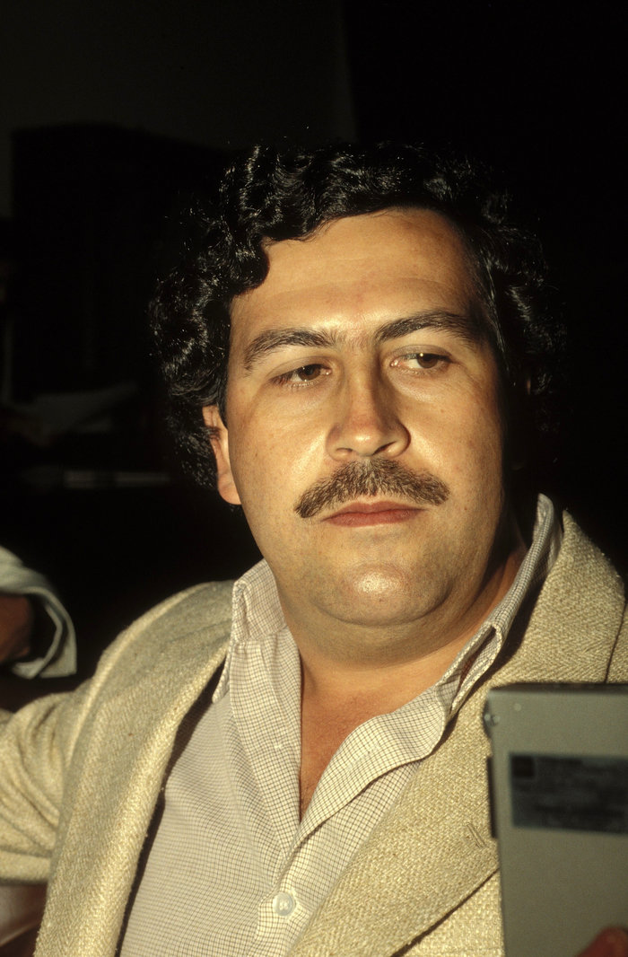 Portrait of a Pablo Escobar with curly hair and mustache, symbolizing a leader who changed history dramatically.