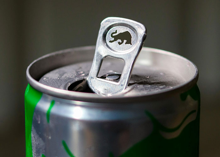 Close-up of an opened soda can tab with a bear cutout symbol, highlighting everyday objects linked to trips and injuries.