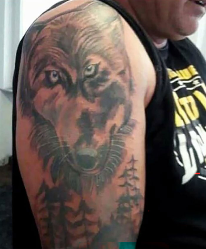 Tattoo fail showing a poorly executed wolf design on upper arm, illustrating ink fails that became permanent regrets.