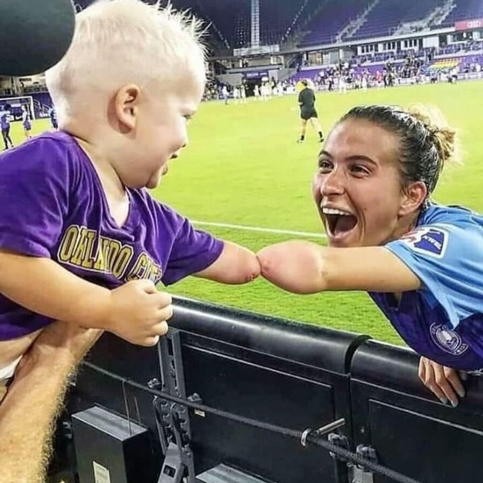 Child and athlete sharing a joyful moment, highlighting uplifting posts about kindness and hope in the world.