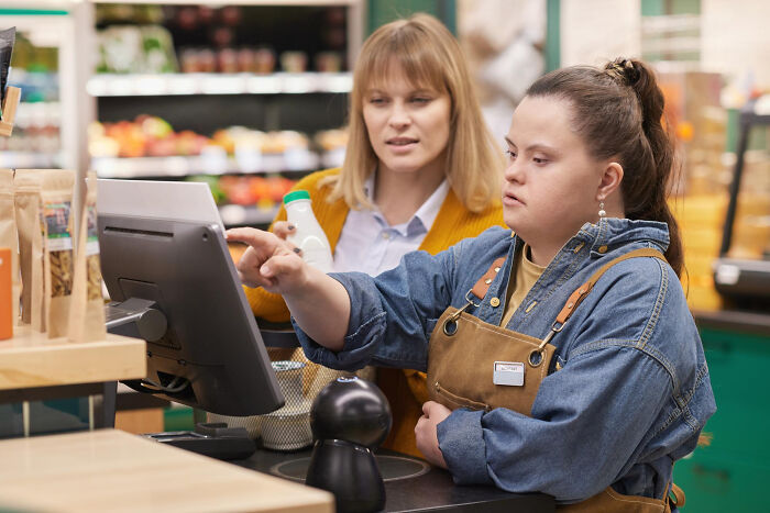 Two women at a grocery store checkout using a touchscreen, illustrating diverse generations reacting to the Gen Z stare.