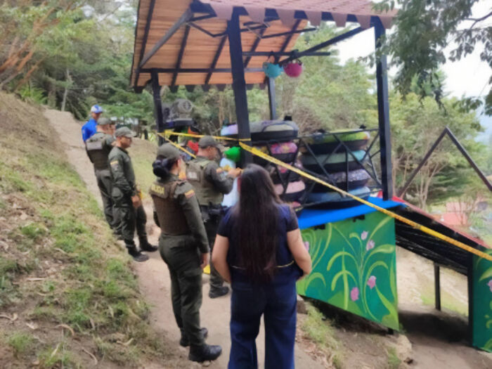 Police officers and a woman at a slide scene secured with caution tape in a horrifying video incident.