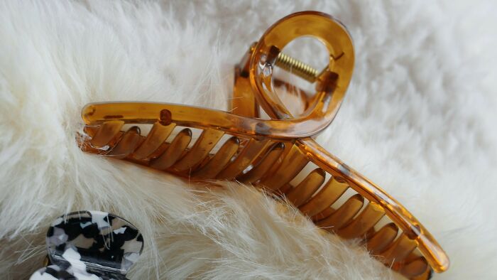 Brown hair clip resting on a fluffy white surface, showing a common childhood item many thought was unique.