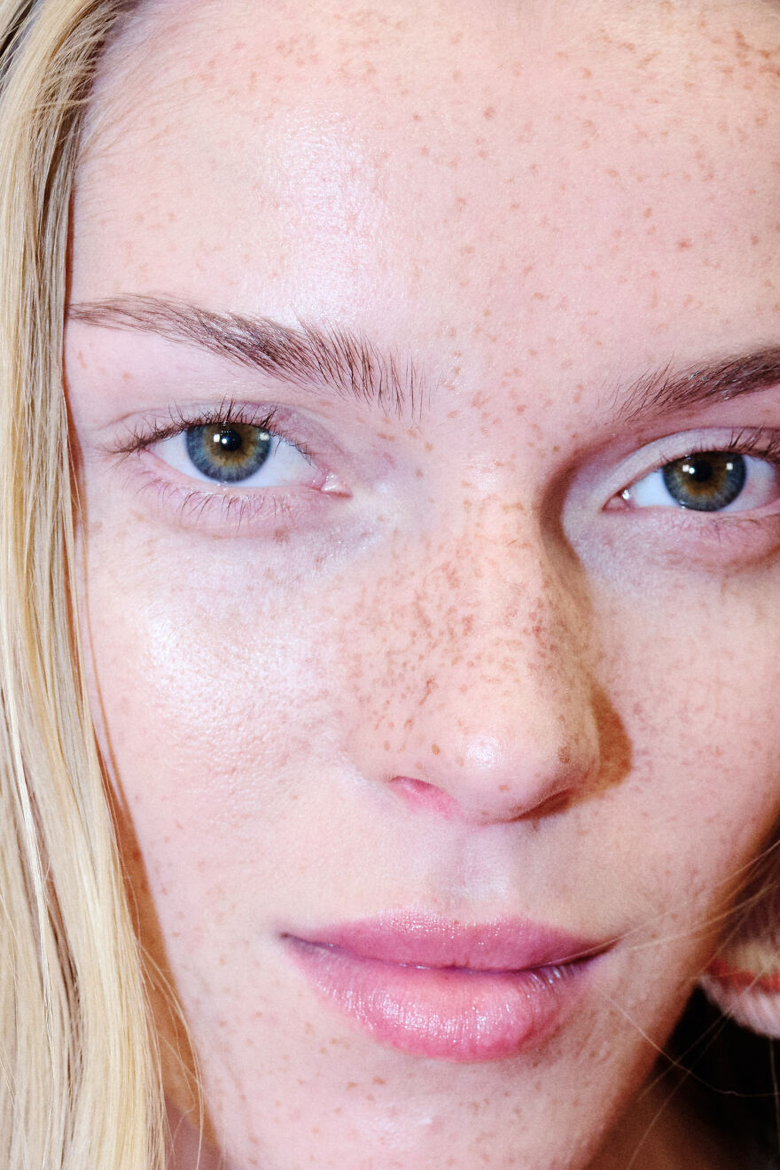 Close-up of a woman with rare green eyes, light freckles, and natural skin, highlighting genetics and eye color origins. Close-up of a woman with rare green eyes, light freckles, and natural skin, highlighting genetics and eye color origins.