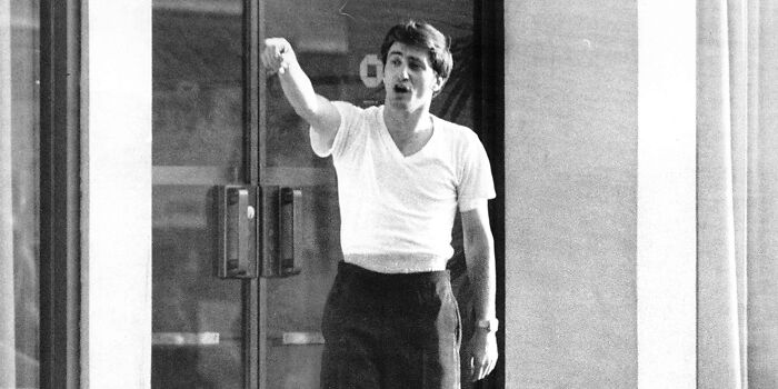 Man in white shirt and dark pants passionately pointing, capturing a crazy thing people did for love moment.